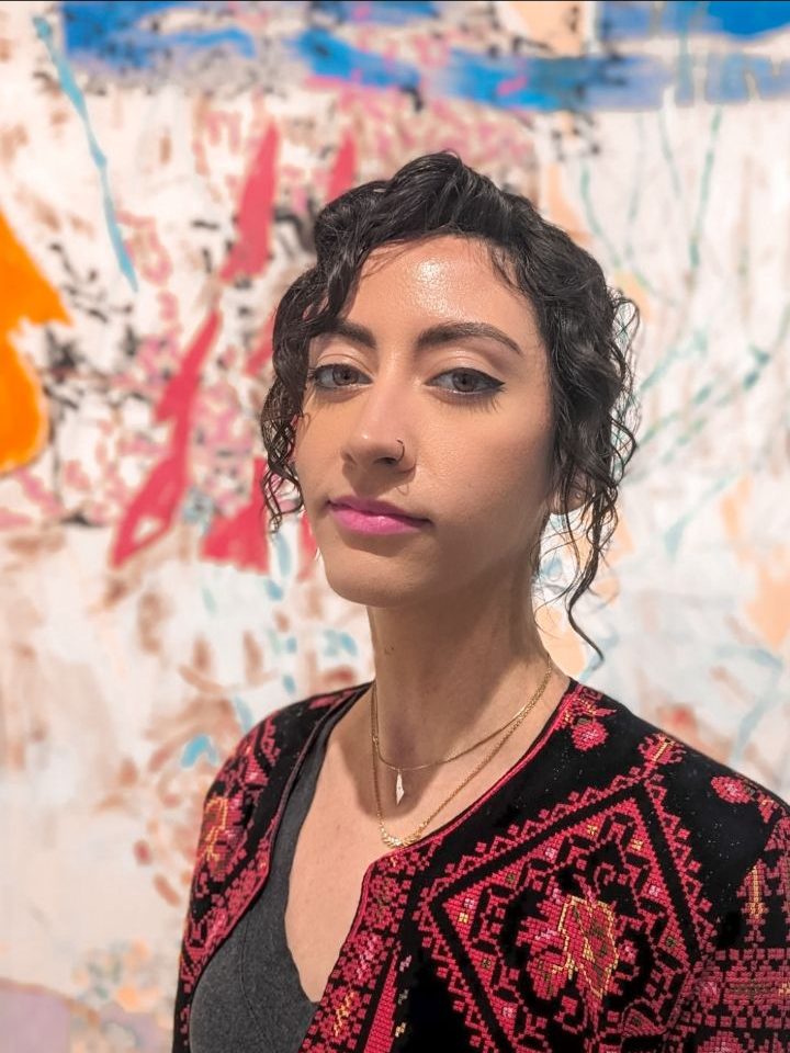 Author Mina Zafri pictured in front of abstract wall art. 